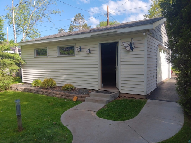 405 10th Ave, Two Harbors, MN 55616 - view of front of property featuring a garage, a front lawn, and an outbuilding