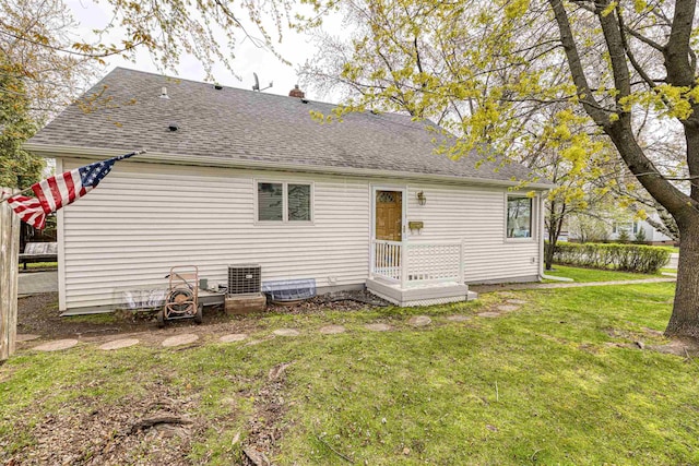 405 10th Ave, Two Harbors, MN 55616 - rear view of property with a yard, a shingled roof, cooling unit, and a chimney