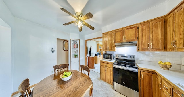 405 10th Ave, Two Harbors, MN 55616 - kitchen featuring appliances with stainless steel finishes, under cabinet range hood, a ceiling fan, light countertops, and brown cabinets