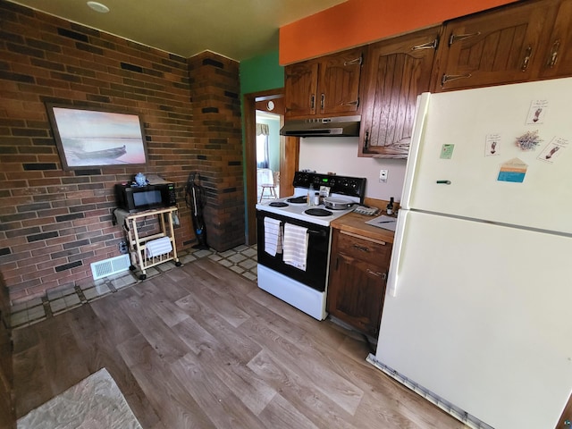 111 E Nebraska Ave, Gilbert, MN 55741 - kitchen featuring freestanding refrigerator, electric range oven, under cabinet range hood, black microwave, and light wood-style flooring