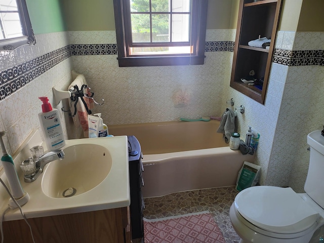111 E Nebraska Ave, Gilbert, MN 55741 - bathroom with toilet, a bathtub, healthy amount of natural light, tile walls, and a wainscoted wall