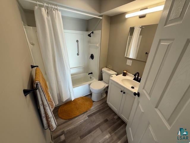 710 N Boundary Ave, Duluth, MN 55810 - full bathroom featuring vanity, toilet, wood finished floors, and shower / bath combo with shower curtain