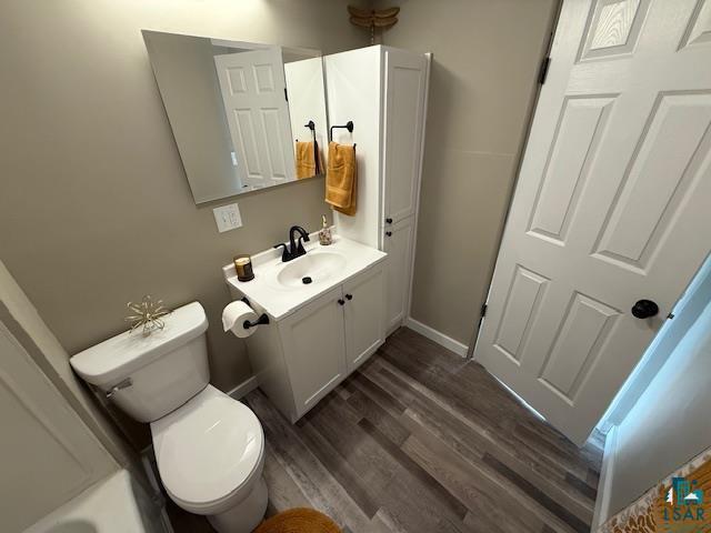 710 N Boundary Ave, Duluth, MN 55810 - full bath featuring vanity, toilet, wood finished floors, baseboards, and a bath