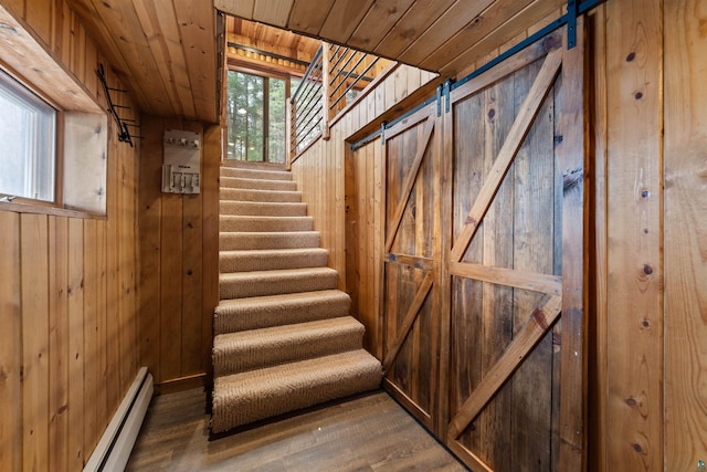 8845 Pequaywan Lake Rd, Duluth, MN 55803 - staircase featuring wooden walls, a baseboard radiator, wood finished floors, a barn door, and wood ceiling