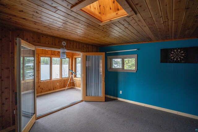 8845 Pequaywan Lake Rd, Duluth, MN 55803 - carpeted empty room featuring wood ceiling, baseboards, wood walls, and a skylight