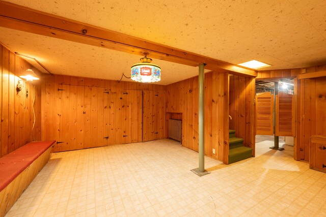 1205 Summit Ave, Cloquet, MN 55720 - finished basement with light floors, stairs, wood walls, and radiator heating unit
