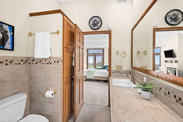5491 N Shore Dr, Duluth, MN 55804 - bathroom with toilet, tile patterned floors, tile walls, ensuite bathroom, and vanity