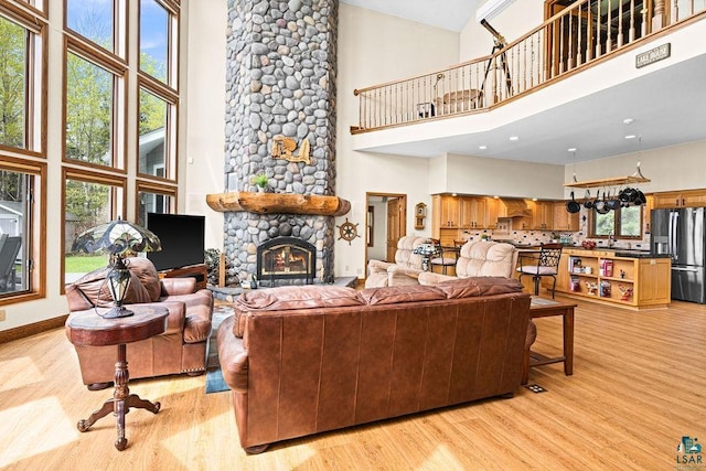 5491 N Shore Dr, Duluth, MN 55804 - living room with high vaulted ceiling, light wood-style flooring, and a stone fireplace