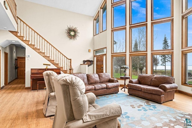 5491 N Shore Dr, Duluth, MN 55804 - living room with a high ceiling, light wood-style floors, baseboards, and stairway