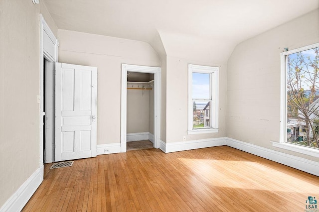 220 N 12th Ave E, Duluth, MN 55805 - unfurnished bedroom with light wood-type flooring, a closet, lofted ceiling, and baseboards