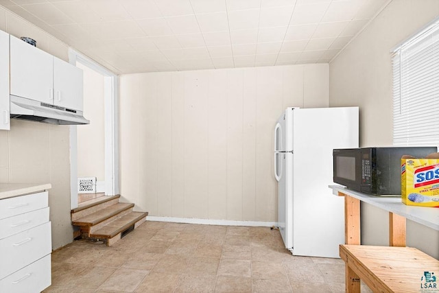 220 N 12th Ave E, Duluth, MN 55805 - kitchen featuring freestanding refrigerator, under cabinet range hood, black microwave, white cabinetry, and light countertops