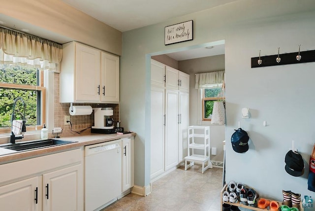 2120 Carlton Ave, Cloquet, MN 55720 - kitchen featuring white dishwasher, tasteful backsplash, white cabinets, a sink, and light countertops