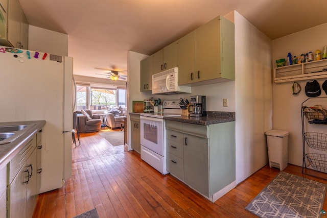 13359 Villa Rd, Ely, MN 55731 - kitchen with white appliances, light wood-type flooring, ceiling fan, dark countertops, and open floor plan