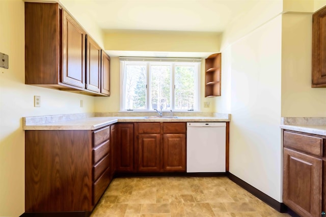 335 E Willow St, Duluth, MN 55811 - kitchen with white dishwasher, a sink, light countertops, and brown cabinetry