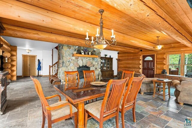 4015 E Van Rd, Duluth, MN 55803 - dining space featuring wood ceiling, a fireplace, a chandelier, stone tile flooring, and rustic walls