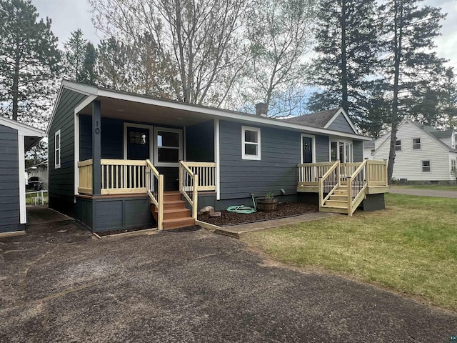 10 Canosia Rd, Esko, MN 55733 - view of front of home featuring a porch, a chimney, and a front lawn
