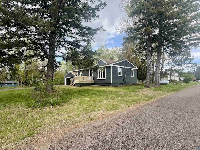 10 Canosia Rd, Esko, MN 55733 - view of side of property with a wooden deck and a lawn