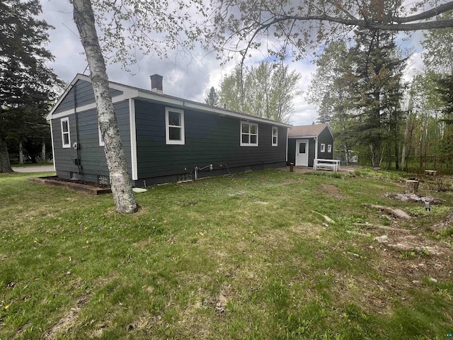 10 Canosia Rd, Esko, MN 55733 - rear view of house with a lawn and a chimney