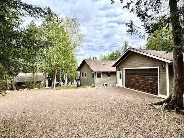 473 S Gunflint Lk, Grand Marais, MN 55604 - ranch-style house with gravel driveway, an attached garage, and roof with shingles