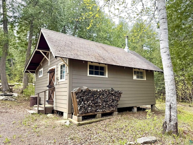 473 S Gunflint Lk, Grand Marais, MN 55604 - view of side of property featuring an outdoor structure and a shingled roof