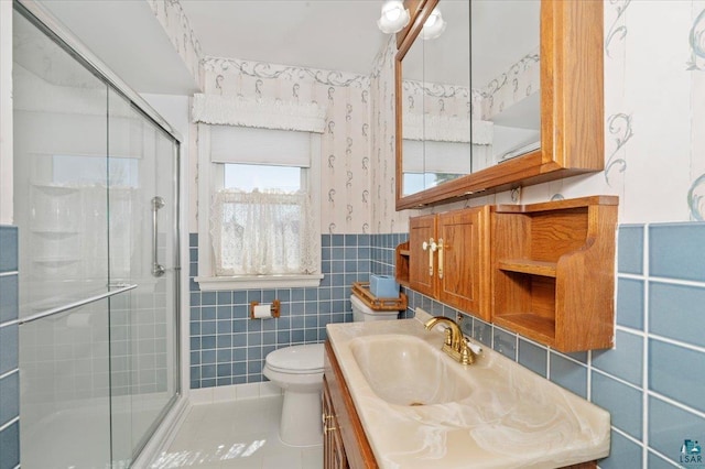 5526 W 8th St, Duluth, MN 55807 - bathroom with tile walls, a shower stall, toilet, vanity, and tile patterned floors