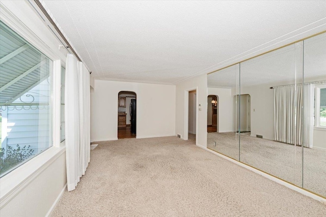 5526 W 8th St, Duluth, MN 55807 - unfurnished bedroom featuring arched walkways, carpet, a closet, baseboards, and a textured ceiling