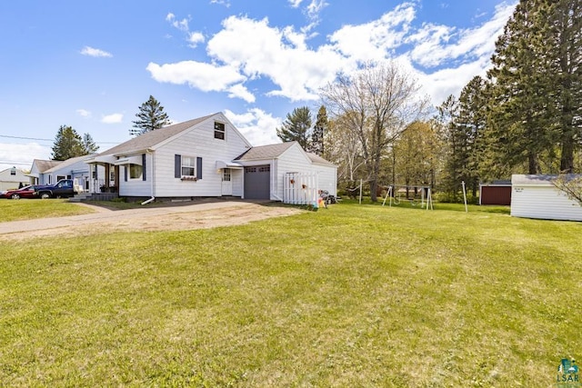 2611 Chambersburg Ave, Duluth, MN 55811 - view of side of home featuring an attached garage, a lawn, an outdoor structure, and driveway