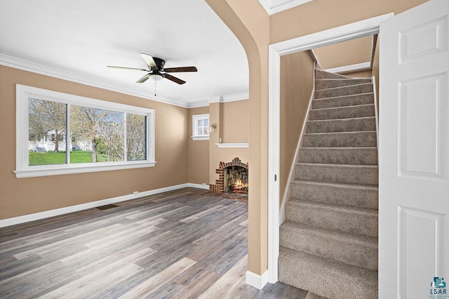 4124 Gilliat St, Duluth, MN 55804 - stairs featuring wood finished floors, crown molding, ceiling fan, a brick fireplace, and baseboards