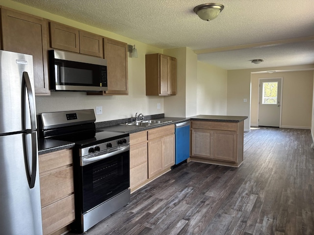 408 Midway Ave, Proctor, MN 55810 - kitchen with appliances with stainless steel finishes, a sink, dark countertops, dark wood finished floors, and a textured ceiling