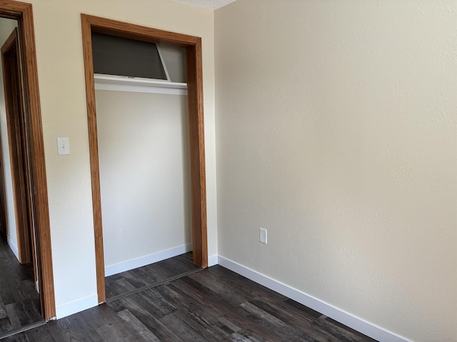 408 Midway Ave, Proctor, MN 55810 - unfurnished bedroom with a closet, dark wood-style flooring, and baseboards