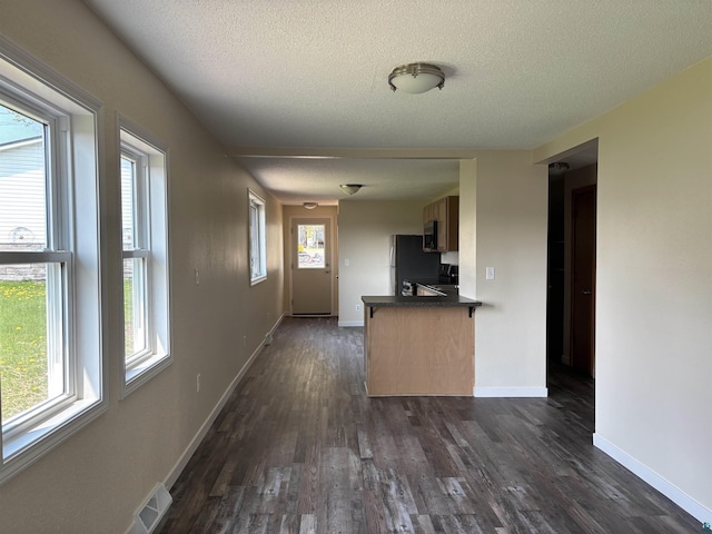 408 Midway Ave, Proctor, MN 55810 - kitchen with dark wood-style flooring, dark countertops, a textured ceiling, stainless steel appliances, and a peninsula