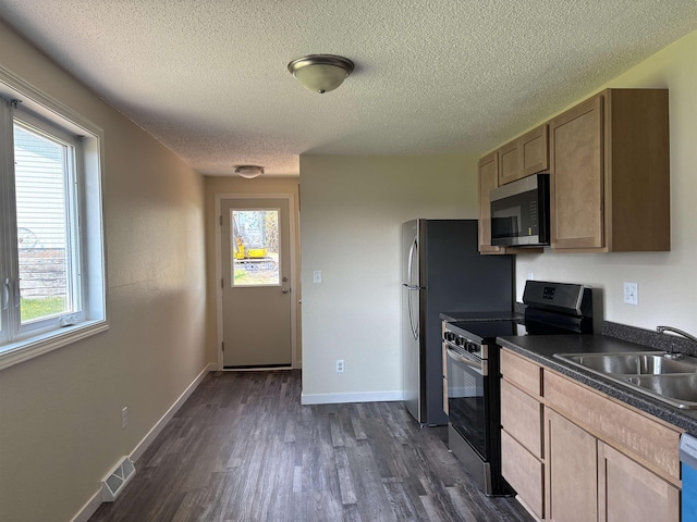 408 Midway Ave, Proctor, MN 55810 - kitchen with stainless steel appliances, dark countertops, a sink, dark wood-style flooring, and a textured ceiling