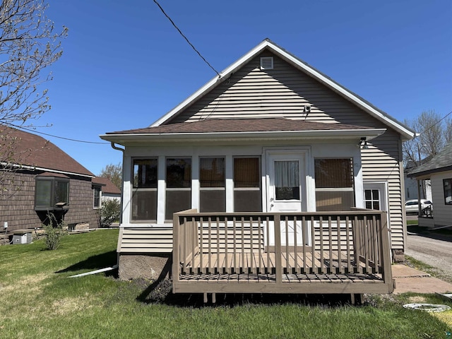 132 1st St, Proctor, MN 55801 - back of property with a sunroom, a lawn, and a deck