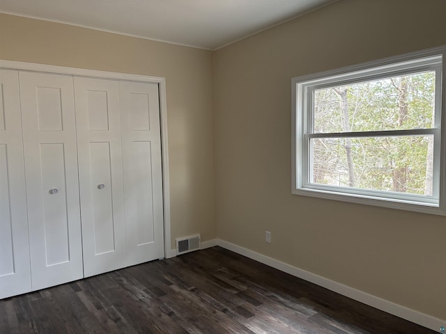 1417 N 7th Ave E, Duluth, MN 55805 - unfurnished bedroom featuring dark wood-type flooring, baseboards, a closet, and crown molding
