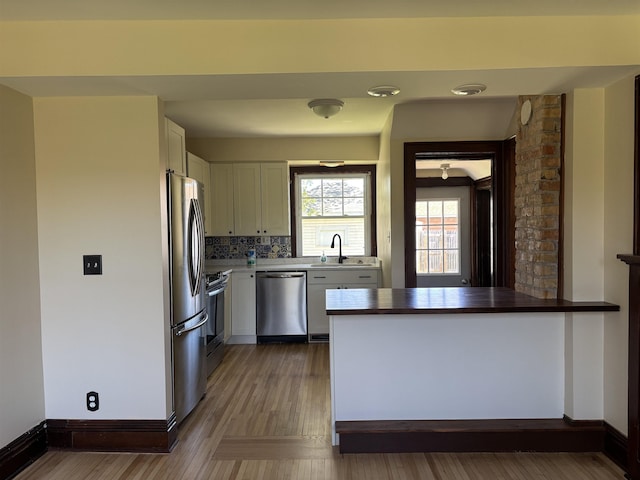 620 N 40th Ave W, Duluth, MN 55807 - kitchen featuring stainless steel appliances, white cabinetry, a sink, wood finished floors, and baseboards