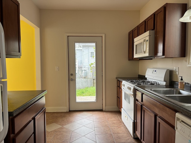 819 N 10th Ave E, Duluth, MN 55805 - kitchen with white appliances, dark countertops, and baseboards