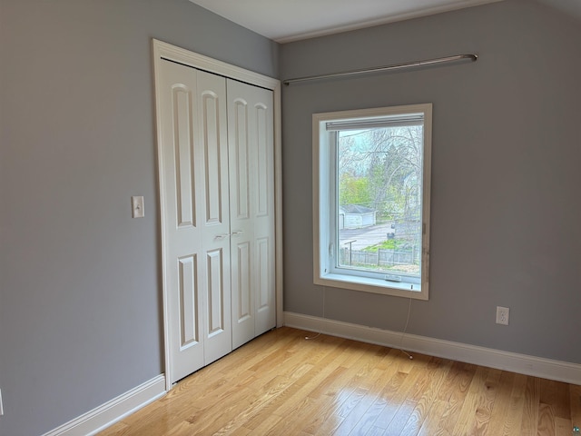 819 N 10th Ave E, Duluth, MN 55805 - unfurnished bedroom featuring light wood finished floors, a closet, and baseboards