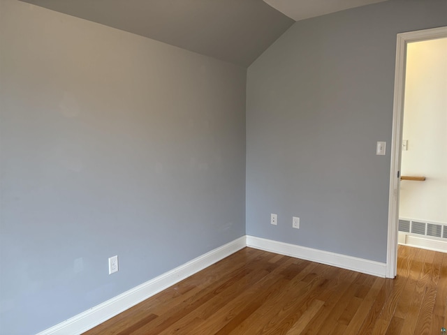 819 N 10th Ave E, Duluth, MN 55805 - unfurnished room featuring baseboards, vaulted ceiling, and wood finished floors
