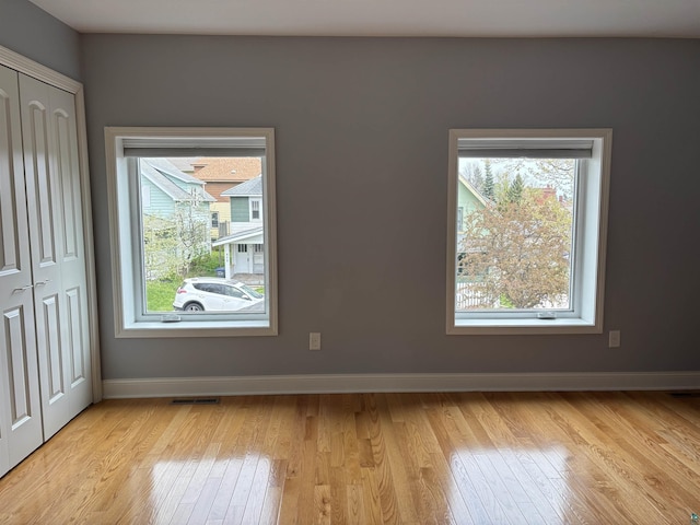 819 N 10th Ave E, Duluth, MN 55805 - unfurnished bedroom with multiple windows, light wood-style floors, and baseboards