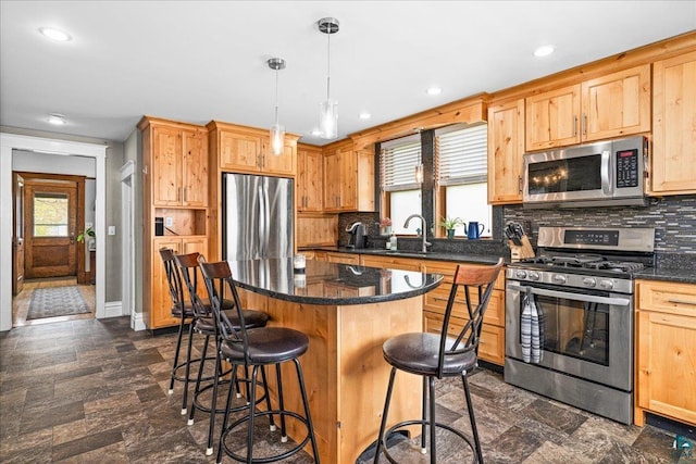 26 N 59th Ave W, Duluth, MN 55807 - kitchen featuring stainless steel appliances, a breakfast bar, a sink, decorative backsplash, and a kitchen island