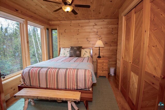 258 Soderberg Ln, Grand Marais, MN 55604 - bedroom featuring wooden walls, wooden ceiling, wood finished floors, and a ceiling fan