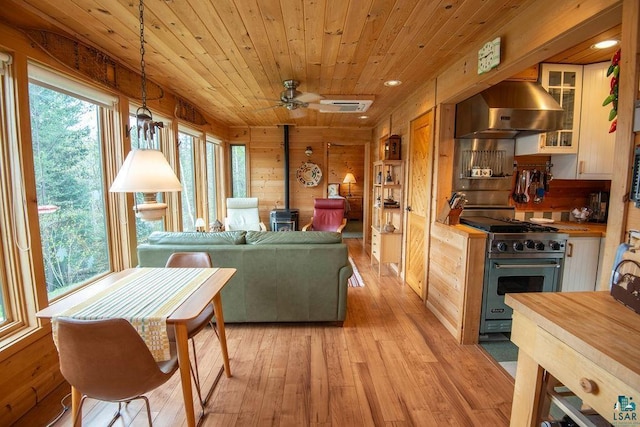 258 Soderberg Ln, Grand Marais, MN 55604 - living room with a wood stove, light wood finished floors, wood ceiling, ceiling fan, and recessed lighting