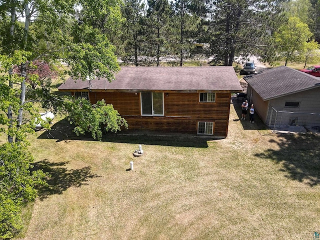 4527 Vermilion Trl, Gilbert, MN 55741 - back of property featuring a yard, roof with shingles, and view of wooded area