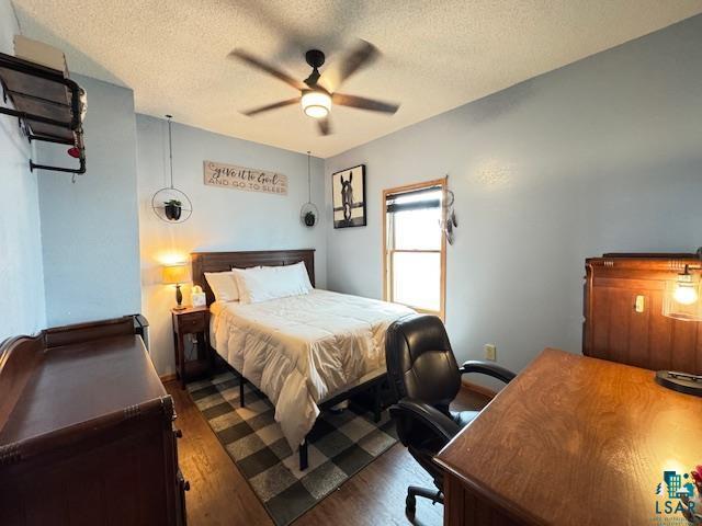 1917 Greysolon Rd, Duluth, MN 55812 - bedroom with dark wood-style floors, a textured ceiling, an office area, and ceiling fan