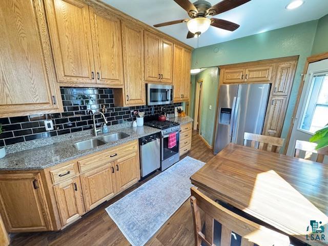 1917 Greysolon Rd, Duluth, MN 55812 - kitchen featuring stainless steel appliances, a sink, decorative backsplash, a ceiling fan, and dark wood-style flooring