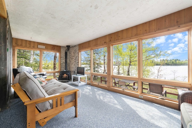 9320 W Branch Rd, Duluth, MN 55803 - sunroom / solarium featuring a wood stove, a textured ceiling, wood walls, and carpet