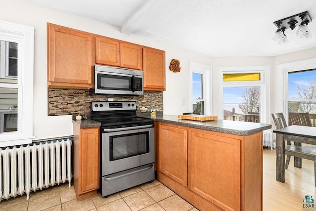619 W Skyline Pkwy, Duluth, MN 55806 - kitchen featuring stainless steel appliances, radiator heating unit, a peninsula, backsplash, and beam ceiling