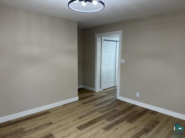 402 N Elba Ave, Eveleth, MN 55734 - spare room with baseboards, wood finished floors, and a chandelier