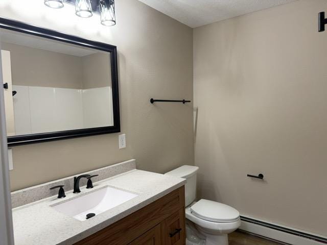 402 N Elba Ave, Eveleth, MN 55734 - bathroom featuring a baseboard heating unit, toilet, and vanity