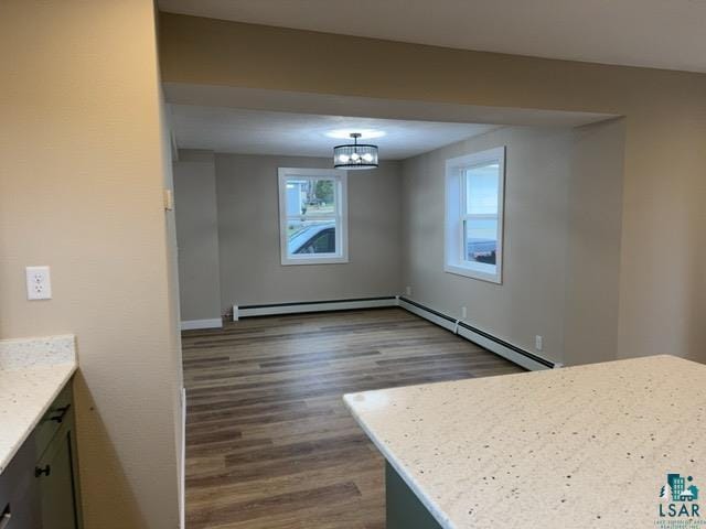402 N Elba Ave, Eveleth, MN 55734 - unfurnished dining area with dark wood-style flooring, a chandelier, baseboard heating, and baseboards